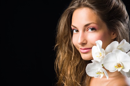 Gorgeous brunette closeup beauty shot with white orchid.の写真素材