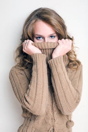 Beautiful winter fashion girl playing with her turtleneck sweater.の写真素材
