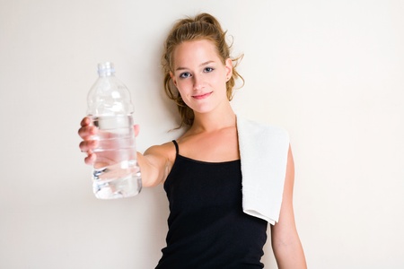 Portrait of beautiful young blond woman offering water.の写真素材
