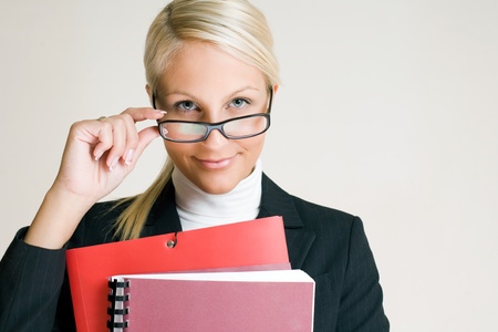 Portrait of cheerful young business woman in glasses holding folders.の写真素材