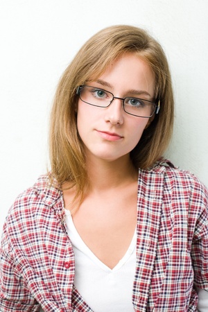Closeup portrait of young student girl in checked shirt wearing glasses.の写真素材