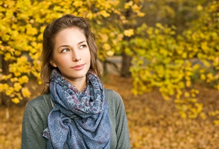 Portrait of gorgeous fashionable young brunette in the park at autumn.の写真素材