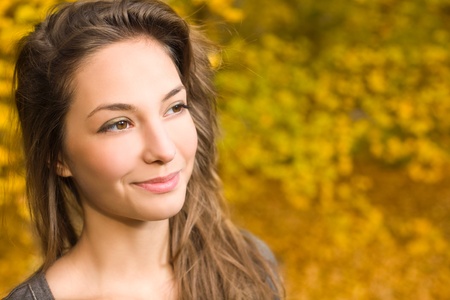 Portrait of gorgeous fashionable young brunette in the park at autumn.の写真素材
