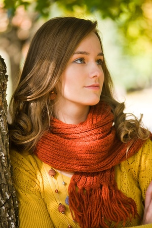 Closeup portrait of gorgeous young brunette woman in the park at autumn.の写真素材