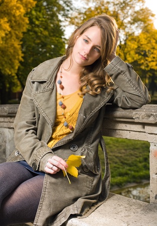 Beautiful young fashionable woman posing in autumn park.の写真素材