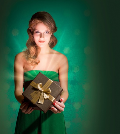 Half length portrait of young blond holding present box with creative lighting.の写真素材
