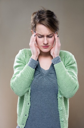Half length portrait of a young brunette woman with terrible headache...の写真素材