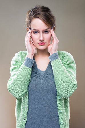 Half length portrait of a young brunette woman with terrible headache...の写真素材