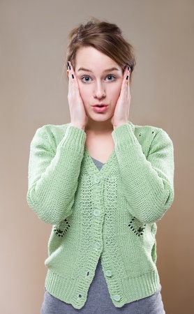 half length portrait of young brunette woman with very surprised facial expression.の写真素材