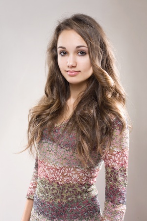 Portrait of fashionable young brunette girl in blue jeans and sweater.の写真素材