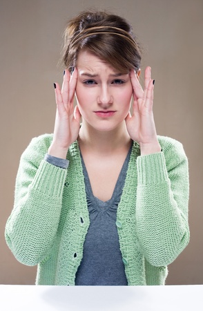 Portrait of beautiful tired young brunette woman with migrane.の写真素材