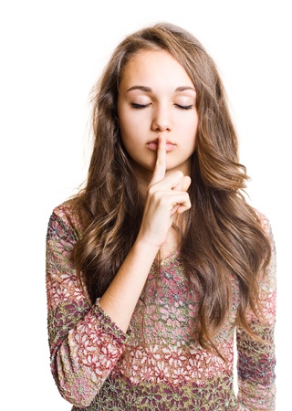 Portrait of a  beautiful young brunette making hush gesture.の写真素材