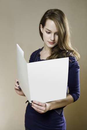 Portrait of beautiful young brunette with blank white folder.の写真素材