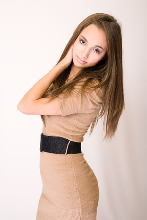 Half length portrait of striking brunette beauty in beige dress.の写真素材
