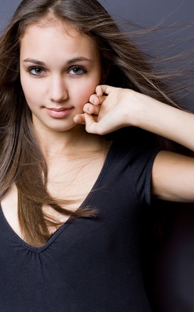 Dark moody portrait of a gorgeous young model girl posing with windswept hair.の写真素材