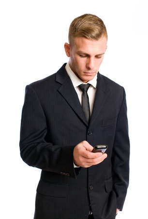 Portrait of a young businessman checking his mobile phoneの写真素材