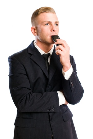 Portrait of a young businesman in thoughtful posture with his mobile phone.の写真素材