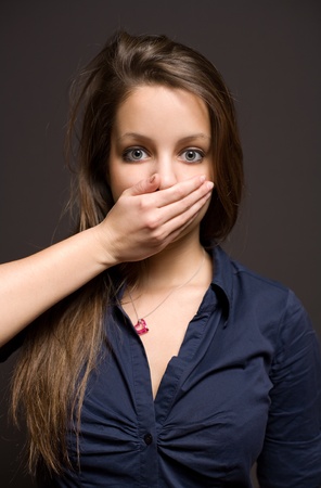 Dark moody portrait of scared looking young brunette woman.の写真素材