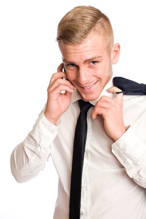 Young businessman with mischievious smile talking on his mobile phone の写真素材