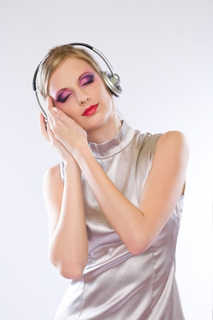 Beautiful blond electro pop gir enjoying music in headphones.の写真素材