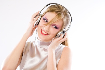 Silver pop girl, beautiful young blond girl with colorful makeup enjoying music in headphones.の写真素材
