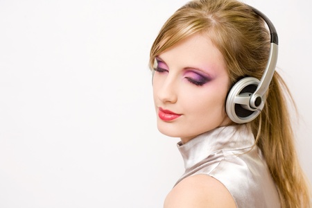 Beautiful blond electro pop gir enjoying music in headphones.の写真素材