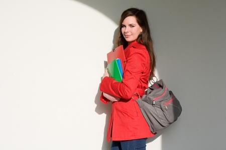 Portrait of a friendly very colorful young student girl holding exercise books.の写真素材