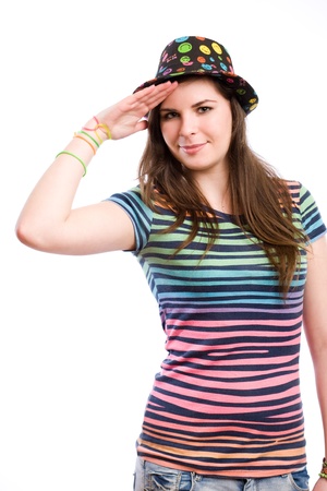 Portrait of a young brunette girl in colorful clothes doing funny salute.の写真素材