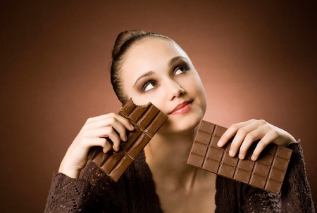 Portrait of a striking brunette beauty enjoying chocolate desserts