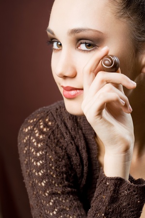 Chocolate addiction, moody portrait of gorgeous brunette with chocolate pralines の写真素材