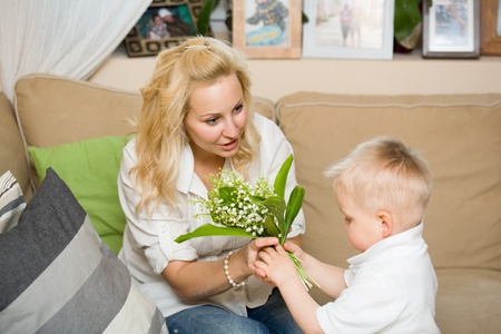 Gift flowers for my mom, baby son and his mother habving fun.の写真素材