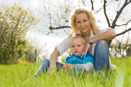 Portrait of an attractive mom and her son outdoors in the garden at spring.の写真素材