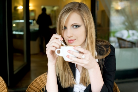 Portrait of a beautiful elegant young blond woman having coffee.の写真素材