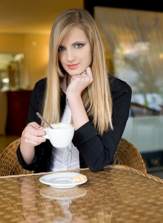 Portrait of a beautiful elegant young blond woman having coffee.の写真素材