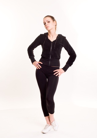Full length portrait of a young brunette standing in fitness outfit.の写真素材
