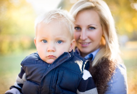 Portrait of an attractive young mother with her son in the park.の写真素材