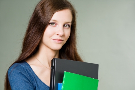 Portrait of a beautiful young student girl holding laptop.の写真素材