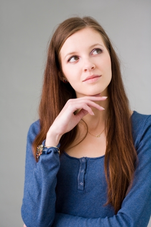 Portrait of a pretty young brunette student girl pondering.の写真素材