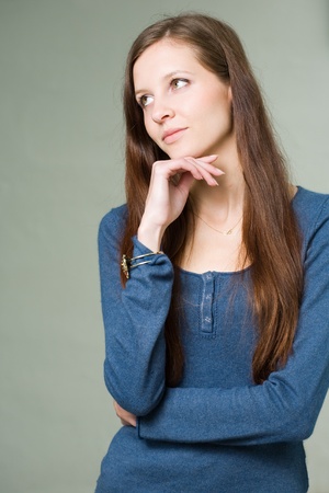 Portrait of a pretty young brunette student girl pondering.の写真素材