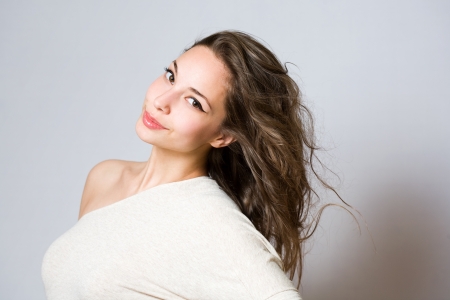 Portrait of a fashionable smiling young brunette in white top.の写真素材