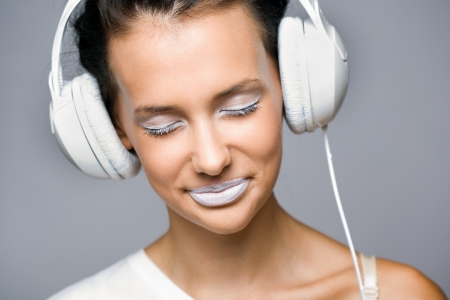 White noise, gorgeous young brunette woman listening to music in headphones.の写真素材