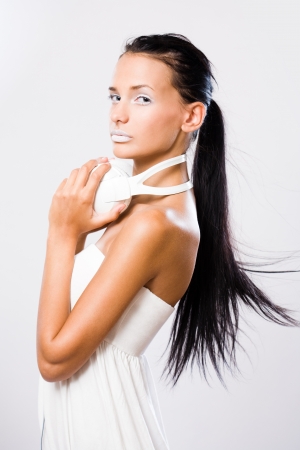 Dreamy young music lover, beautiful young brunette wearing big white headhones.の写真素材