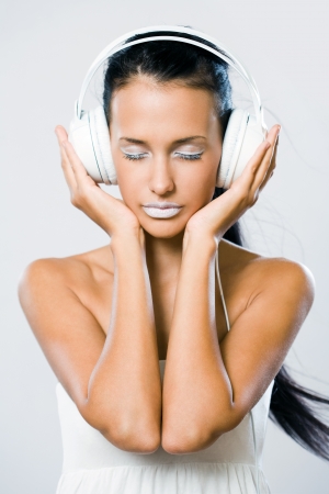 White noise, gorgeous young brunette woman listening to music in headphones.の写真素材