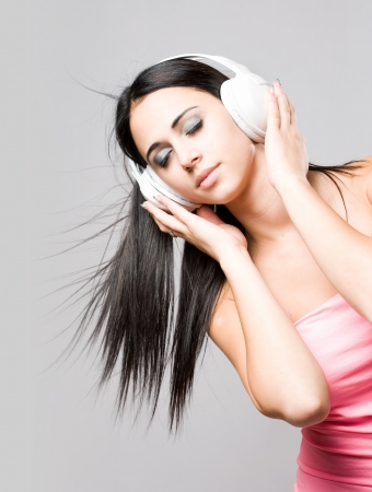 Portrait of a beautiful dreamy young brunette enjoying music の写真素材