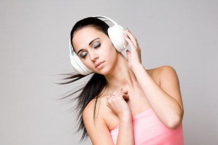 Portrait of a beautiful dreamy young brunette enjoying music の写真素材