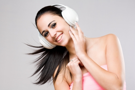Portrait of a brunette beauty enjoying music in white headphones の写真素材