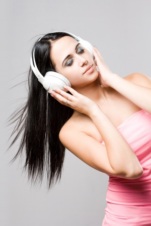 Gorgeous brunette music lover wearing bright white headhones の写真素材