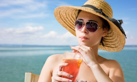 Portrait of a summer brunette with beach refreshment.の写真素材