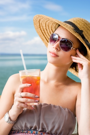 Sunny portrait of a young brunette relaxing at the beach.の写真素材