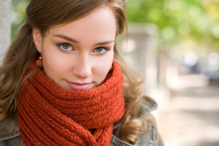 Portrait of a fashionable friendly cheerful young blond woman outdoors at fall.の写真素材